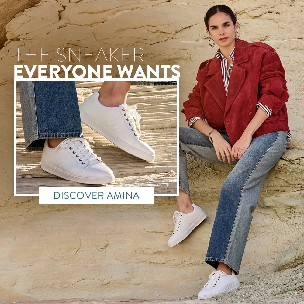 The Sneaker Everyone Wants. Discover Amina. A woman sitting on a rock formation wearing the Amina lace up sneakers in white.