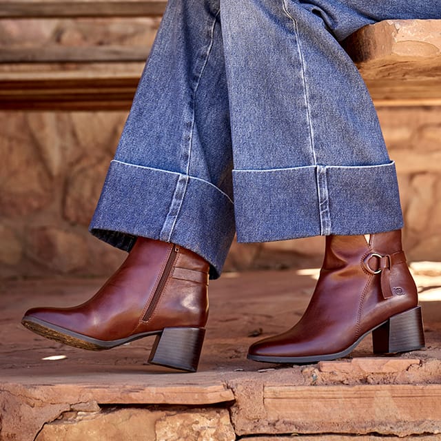 A woman wearing the Livvy heeled ankle boot in brown. Shop Livvy.